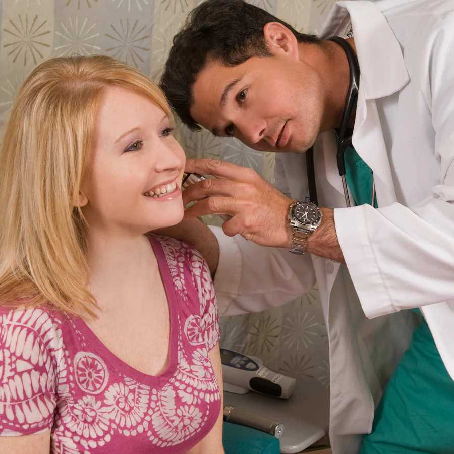 Physician examining a patient's ear with an otoscope